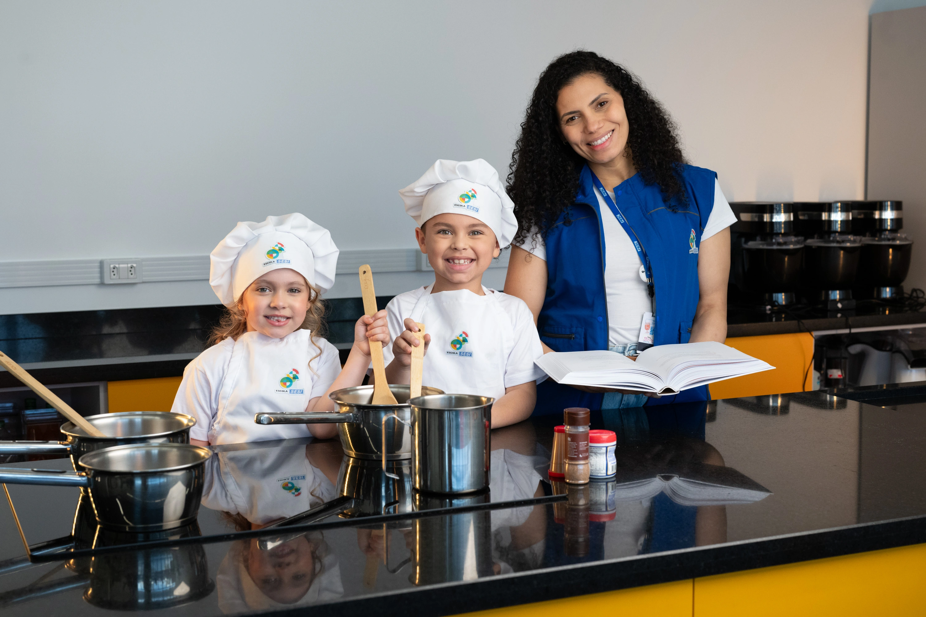 Imagem de três crianças brincando com a professora